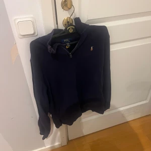 Mörkblå halvzip tröja från Polo Ralph Lauren - Säljer nu min Mörkblå långärmade tröja från Polo Ralph Lauren med halv dragkedja och klassisk broderad logga på bröstet. Perfekt för en stilren och avslappnad look. Mjuk bomullskvalitet och normal passform. Det är XL i ungdom storlek vilket motsvarar S. Hör av er vid frågor 👍