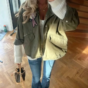 Olivgrön jacka med broderade detaljer - Superfin jacka med coola detaljer 💓 (första bilden är lånad) köpt på Plick, använd av mej fåtal gånger! TRYCK KÖP NU