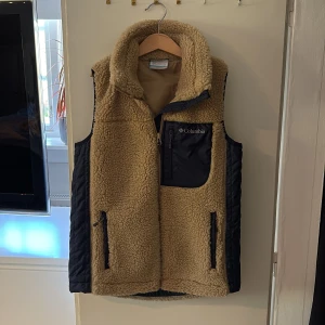 Fleeceväst från Columbia - Säljer en beige fleeceväst från Columbia med mörkblå detaljer. Max änvänd 2-3 gånger, inga defekter. 