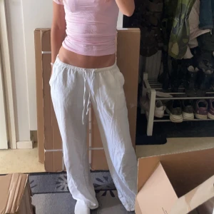 Vita linnebyxor  - Säljer ett par vita linnebyxor med avslappnad passform. Byxorna har raka ben och är perfekta för varma dagar. Lätta och luftiga, passar till många olika stilar.