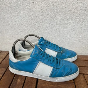 Flycrews  - Snygga sneakers i blått och vitt med klassisk design och rund tå. Skorna har platt sula och snörning framtill. Perfekta för vardagsbruk och passar till många olika outfits.