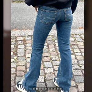 Blå bootcut jeans från junkyard - Säljer ett par klassiska blå bootcut jeans från Junkyard med fem fickor och snygga kontrastsömmar. Jeansen är lågmidjade.  Aldrig använda, lånade bilder, nypris: 600