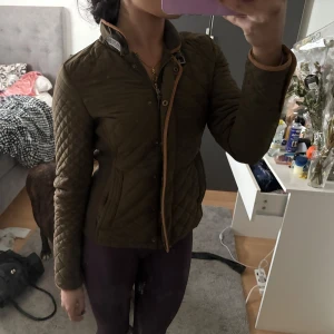 Olivgrön quiltad jacka med bruna detaljer - Från Zara, gammal modell. 