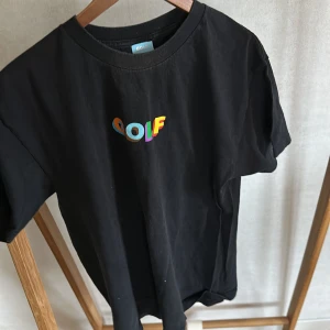 Svart t-shirt från Golf med färgglad logga - Svart t-shirt från Golf Wang med en liten 'GOLF'-logga tryckt på bröstet.