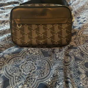 Lacoste magväska - Säljer väskan pga ingen användning av den, den har använts 1 gång, pris kan diskuteras vid snabb affär, nypris 2045kr