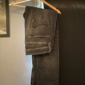 Mörkgrå jeans från Jack & Jones - Snygga mörkgrå jeans från Jack & Jones med klassisk femficksdesign och diskret slitning. Jeansen har raka ben och normal passform, perfekta till en avslappnad stil. Materialet är robust denim i bomull.