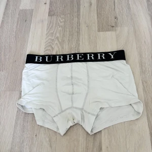 Vita Burberry boxershorts med logotyp - Snygga vita boxershorts från Burberry med bred svart resår och stor vit logga. Mjukt och stretchigt material som sitter skönt. Perfekta för dig som gillar klassisk stil med en lyxig touch.
