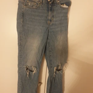 Blå ripped jeans från 157 - Snygga blå jeans från 157 med slitna och trasiga detaljer vid knäna. Klassisk femficksmodell i denim med normal passform och raka ben. Perfekta för en avslappnad och trendig streetstil.