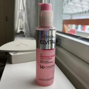 L'Oréal Elvital Glycolic Gloss serum - L'Oréal Paris Elvital Glycolic Gloss Leave-In Serum i en rosa pumpflaska med silverdetaljer. Serumet är berikat med glykolsyra och ger glans till håret. Produkten är använd tre gånger och är därav så gott som ny.🩷