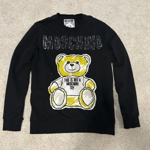 Moschino tröja - Säljer en fin Moschino tröja för ett superbra pris. Storlek L men kan även passa dig som har M. Mycket bra skick inga skador eller slitage! Priset kan sänkas vid snabb affär! Skriv för intresse o mer info! 