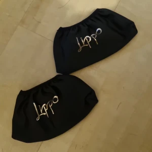 Svarta stigbygelskydd från Lippo - Två svarta stigbygelskydd från Lippo med guldig logga framtill.  Helt nya inte använda 