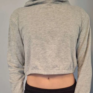 Croppad hoodie - Grå Croppad hoodie från okänt märke. Snygg att ha som den är eller att ha ett linne under. Är inte säker vilken storlek den är men passar xs/s. Pris går att diskuteras och det är rabatt på bundles!