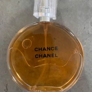 Chanele Chance Eau de Parfum 100ml - Chanel Chance Eau de Parfum i en rund, transparent glasflaska med guldig-orange vätska och stilren logga. Flaskan har en elegant, genomskinlig plastkork och rymmer 100 ml. En ikonisk doft från Frankrike som utstrålar lyx och klass. ‼️‼️Det finns ingen kartong ‼️‼️‼️