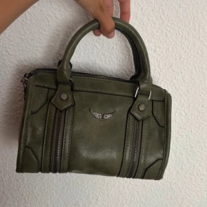 Olivgrön handväska  - Snygg olivgrön handväska i skinnimitation med både handtag och justerbar axelrem. 