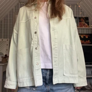 Ljusgrön overshirt från Zara - Snygg ljusgrön overshirt från Zara i denim. Jackan har en avslappnad passform, stora fickor framtill, klassisk krage och knäppning med silvriga knappar. 