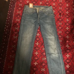 Blå Lee jeans straight fit - Snygga blå jeans från Lee med klassisk femficksdesign och raka ben. Jeansen har tydliga kontrastsömmar, Lee-logga på bakfickan och läderpatch i midjan. Tillverkade i slitstarkt bomullsjeansmaterial och passar perfekt till en avslappnad streetstil.