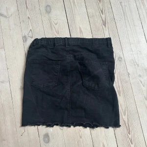Svart jeanskjol med fransig kant - Den är i storlek 14/16 år. Men extremt stretchig och passar mig som är en S/xs.