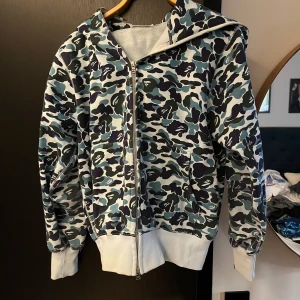 Bape Hoodie full zip - Ikonisk hoodie från bape som har dragkedja på luvan. Storleken på hoodien är M men passar bättre på någon som vanligtvis bär S. Skriv om ni har frågor.