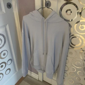 ljusblå hoodie sett - En stilren babyblå hoodie med huva och dragsnören med matchande mjukis byxor  Tröjan är tillverkad i mjukt bomullsmaterial. Perfekt för chill dagar eller när du vill ha en enkel och clean look. dock har byxorna en lite klorin fläck den som finns på bilden därför säljer ja byxorna gratis med hoodien (du betalar bara för hoodien ) 