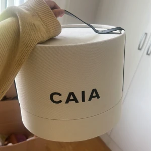 Vit rund väska från CAIA - Säljer förpackningen till caias julkalender 2023, kan användas som inredning eller förvaring