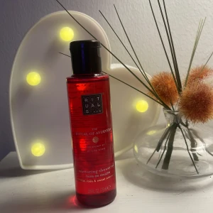 Rituals The Ritual of Ayurveda duscholja - Röd flaska med duscholja från Rituals, The Ritual of Ayurveda. Innehåller 75 ml och doftar av indisk ros och sötmandel. Oljan ger en lyxig känsla och passar perfekt för dig som vill ha en mjuk och återfuktad hud.