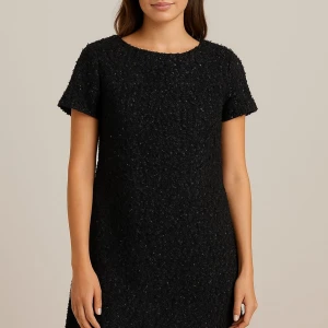 Svart kort klänning från Aspesi - Säljer en svart kort klänning från Aspesi med coolt strukturerat tyg och diskret glans. Klänningen har rund hals, korta ärmar och en liten slits i sidan. Perfekt för dig som gillar stilren men ändå unik look.