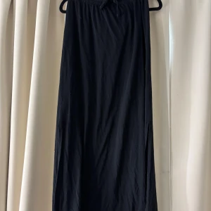 Svart långkjol med slits - snygg svart långkjol med slits på sidorna och resår i midjan med knytband vilket gör att du kan justera midjan så att den passar dig! Superskönt material! Om fler bilder önskas eller vid frågor kontakta mig💋