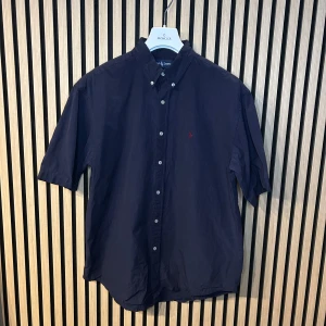 Ralph Lauren kortärmad skjorta  - Svart kortärmad Ralph Lauren skjorta | Skick 9/10 | 65cm bröstvidd, 28cm ärmlängd och 43cm kragmått, storlek: XXL (kan även passa som rymlig XL beroende på passform) | Hör gärna av dig vid minsta fundering😊