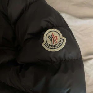 Moncler jacka  - Den är lite trasig vid märket vet ej om den är äkta men det är bra kvalitet. Den är size S men sitter stort så skulle säga att den passar som M. Tveka inte vid frågor! Tar emot pris förslag