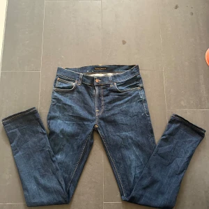 Nudie Jeans - Nudie Jeans av modellen  THIN FINN Storlek: 33/34 - Skicket på jeansen är mycket bra - 10/10 - mitt pris: 499- Nypris: 1599kr.   En stor fördel med Nudies jeans jämfört mot Levis, Tiger of Sweden, Replay, Lee, Acne, dondup osv. Ar att du kan lämna in dem gratis for reparation eller uppläggning i Stockholm, Göteborg eller Malmö. Pa sa vis förlängs livslängden rejalt.