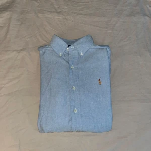 Ralph Lauren Skjorta - En Ljusblå Ralph Laurent skjorta perfekt för sommaren . Fick den i present men säljer den då är för stor för mig. Storlek är S är men passar M då jag själv är S och den är lite för stor för mig. Pris går att diskutera👍💸Skicket är mycket bra då jag bara har använt den en gång.