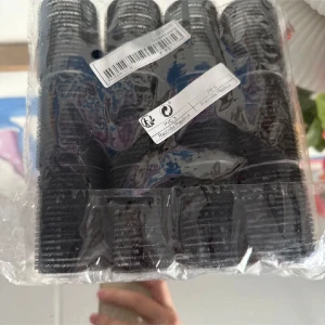 Svarta hårspolar och clips set - Set med svarta hårspolar i plast och matchande svarta clips. Perfekt för att skapa volym och lockar i håret. Spolarna har kardborre för att sitta kvar utan värme och clipsen håller håret på plats under stylingen.