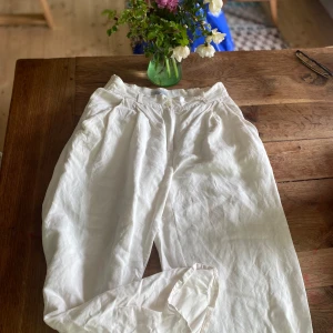 80s/90s vintage Bermudasbyxor - Snygga vita linnebyxor med hög midja och avslappnad passform. Storleksmärkt M men små i storlek (för små på mig tyvärr! Byxorna har, gylf framtill och sidfickor samt en bakficka (se gullig båt). Perfekta för en chill och stilren look under varma dagar. Gissar bomull/halvlinne