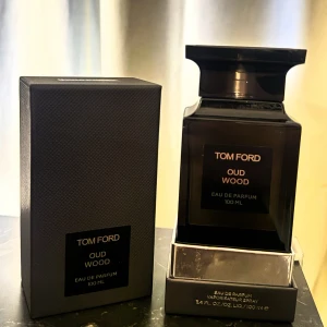 Tom Ford Oud Wood  EdP 3ml sample - Exklusiv parfym från Tom Ford, Oud Wood, i en elegant mörkbrun fyrkantig flaska med svart etikett och silverdetaljer. Flaskan rymmer 100 ml Eau de Parfum och levereras i en lyxig svart kartong med struktur. Perfekt för dig som gillar unika och djupa dofter.