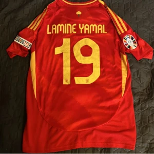 Lamine Yamal Fotbollströja EM 2024 - Säljer en Spanien EM 2024 Fotbollströja i Storlek M med Lamine Yamal 19 på ryggen, inkluderar även EM märket på höger armen 