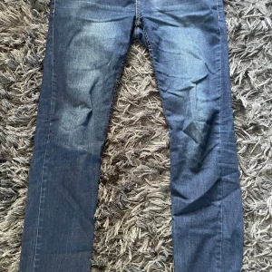 Levi's 512 Slim Taper jeans blå - Snygga blå Levi's 512 Slim Taper jeans med klassisk femficksdesign och gul kontrastsöm. Jeansen har en smal passform som smalnar av nedtill och är tillverkade i slitstarkt denim. Perfekta för dig som gillar en modern och stilren look.