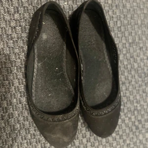 Svarta ballerinaskor med mönstrad kant - Svarta ballerinaskor med rund tå och dekorativ kant med triangulärt mönster🌟. Skorna är i mockaliknande material och har en klassisk, enkel design som passar till många olika outfits. Skorna har storleken 41🩷🙌. 