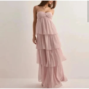 Ljusrosa axelbandslös långklänning - En jättefin ljusrosa klänning. Den är i bra skick bara använd en gång! Storlek XXS men passar mig med XS-S. Hör av er om ni är intresserade eller vill ha mer bilder 