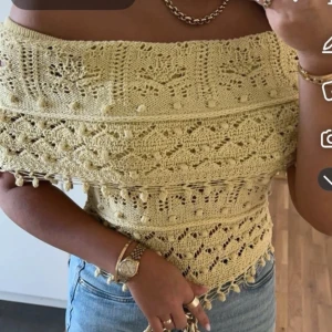 Gul offshoulder stickad topp - Säljer en ljusgul stickad offshoulder topp med virkade detaljer och mönster. Toppen har en croppad passform och är perfekt för varma dagar. Snygg att matcha med jeans eller kjol.