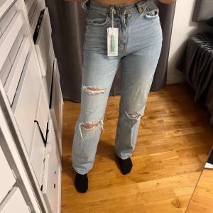 HELT NYA Ljusblå raka jeans - Helt nya och oanvänd (lappar sitter kvar) ljusblå jeansbyxor från Gina Tricot med raka ben och slitningar på båda knäna. Hög midja och klassisk femficksmodell. Modellen 90s high waist jeans, storlek 34, nypris 599kr.