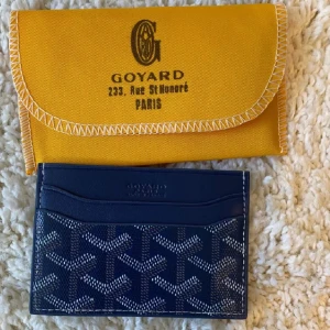 Korthållare  - Säljer ett elegant kortfodral i blå med ikoniskt mönster. Perfekt för att hålla dina kort organiserade. Kommer i en snygg gul orginal förpackning.