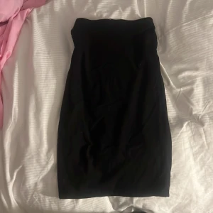 Svart pennkjol från H&M Basic - En klassisk svart pennkjol från H&M Basic. Kjolen har en enkel och stilren design med hög midja och rak passform som slutar under knät. Perfekt att matcha med olika toppar för en snygg look.
