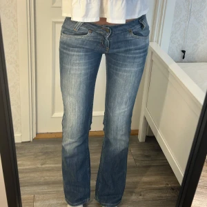 Lågmidjade utsvängda jeans - Jätte fina jeans från Lee i super skick! Storleken är W27 L31 och måtten är: Innerben: 78 cm, midja rakt över: 40 cm Kom privat för fler mått eller frågor🥰