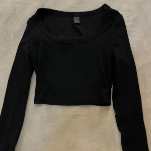 Svart croppad långärmad topp från shein  - Säljer en svart croppad topp från shein med lång ärm och rundad halsringning. Toppen är ribbad och har en tight passform, perfekt att styla till olika outfits.