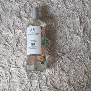 Shea Body Mist från The Body Shop - Fräsch body mist med sheadoft från The Body Shop. Flaskan är genomskinlig med silverfärgat lock och har en etikett med gröna och beige toner samt illustrationer av sheanötter. Vegansk formula och uppfriskande doft. Jag har bara använt lite gran men lukten är inte riktig min smak ☺️