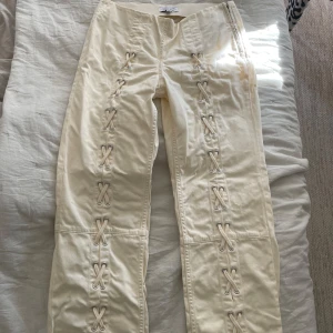 Krämvita byxor med snörning från & Other Stories - Snygga och populära byxor från & Other Stories med snörning längs båda benen framtill.  