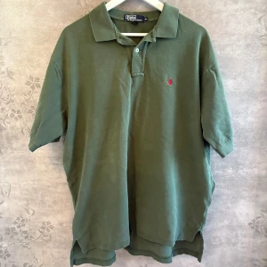 Ralph Lauren piké - Den här gröna Ralph Lauren-pikén har en riktigt snygg, annorlunda nyans och diskreta kontrastdetaljer.  Ralph Lauren, Polo Ralph Lauren, Pikétröja herr, Preppy stil, Klassisk piké, Designer piké, Streetwear, Herrmode, Loggopiké, Sommarstil, Snygg piké, Trendigt plagg.  #ralphlauren #pikétröja #green #unikstil #preppylook #herrkläder  Storlek: XI Skick: Ok, synligt slitage Pris: 180