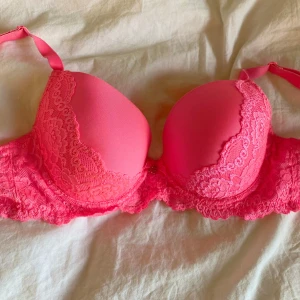 Rosa spets-bh med vaddering - Säljer en snygg rosa bh från Cubus med vadderade kupor och fina spetsdetaljer. Bh:n har justerbara axelband och en feminin design som ger bra stöd och form. Perfekt för dig som vill ha något extra fint i underklädeslådan!