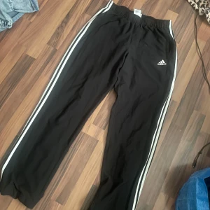 Svarta träningsbyxor från Adidas med vita ränder - Säljer mina svarta adidas byxor, Jag vill sälja de pågrund av att jag inte använder de längre. Men jag har använt byxor väldigt mycket förut men man kan knappt se det, det är bara lite noprrigt vid de vita ränderna men inget man tänker på.💗
