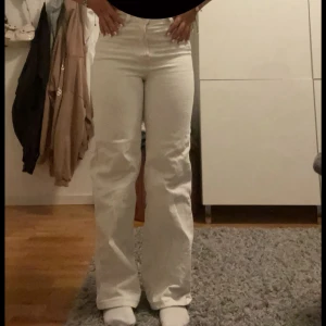 Vita jeans från mango  - Säljer ett par lågmidjade vita jeans från mango  i klassisk femficksmodell. Byxorna har raka ben och normal passform, perfekta för en stilren look. Tidlös design med bälteshällor och diskreta sömmar.